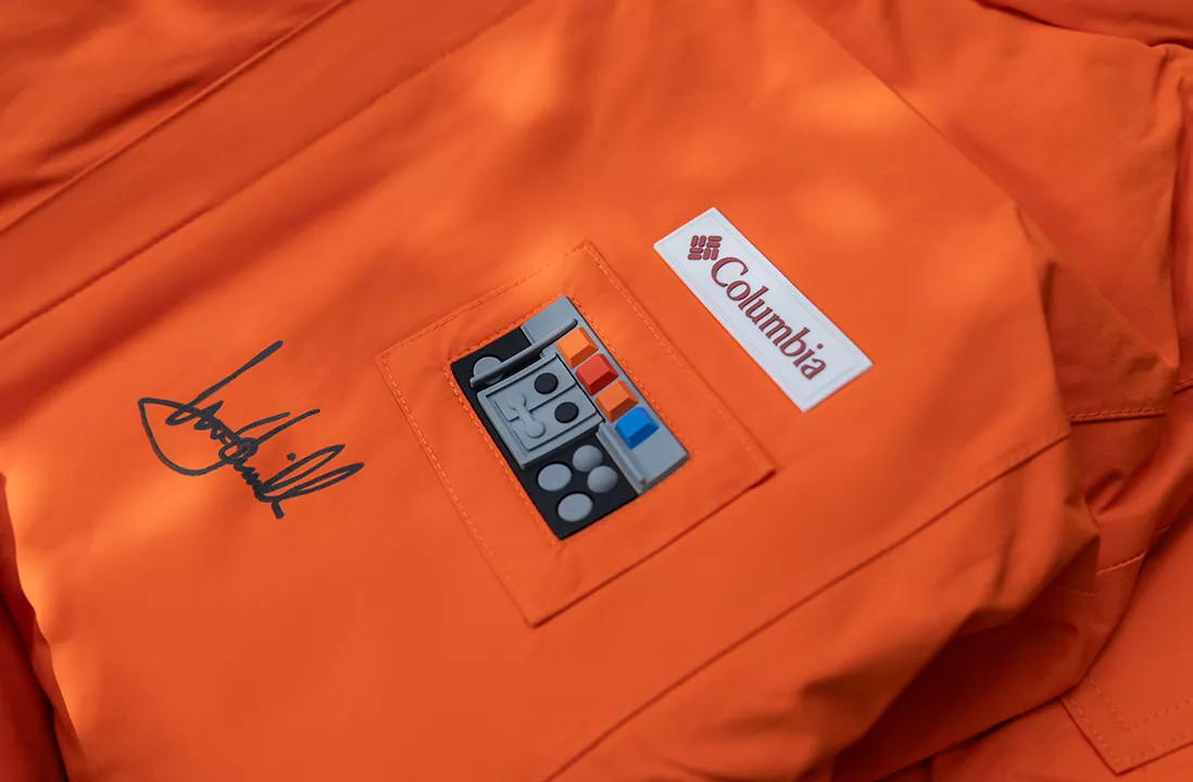 A closeup of Mark Hammill’s autograph on an orange Columbia jacket
