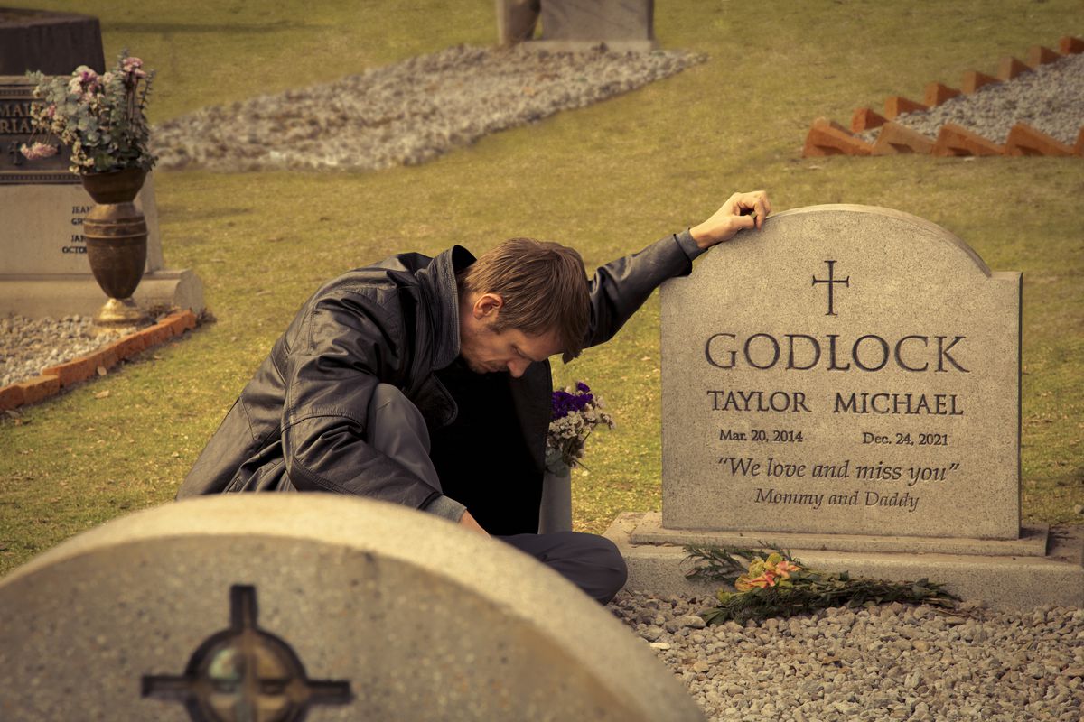 Joel Kinnaman touches a gravestone for Taylor Michael Godlock in Silent Night