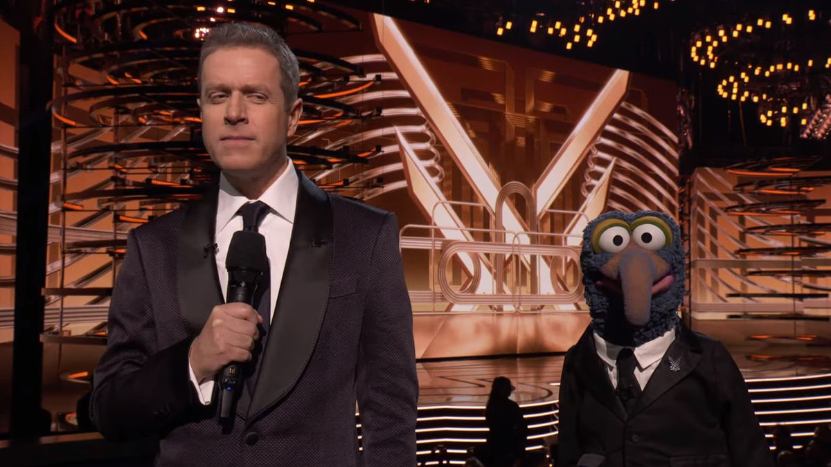 The Game Awards host Geoff Keighley stands next to Gonzo from the Muppets, both wearing similar suits.