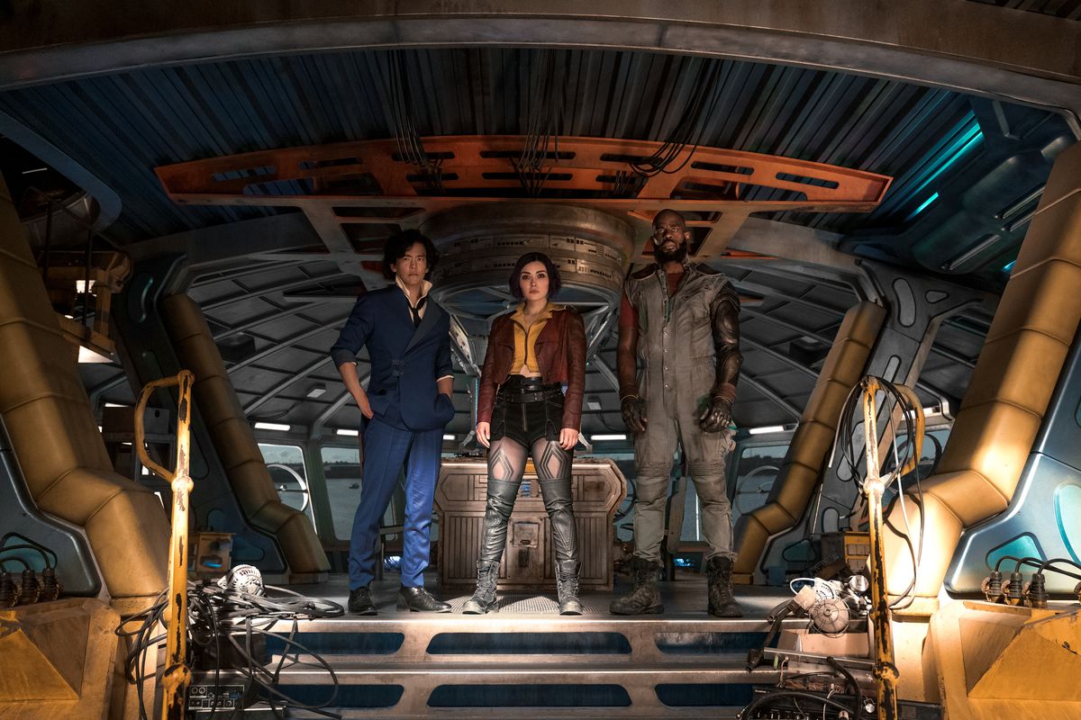 (L-R) John Cho, Daniella Pineda, and Mustafa Shakir standing on the deck of a spacecraft in Cowboy Bebop,