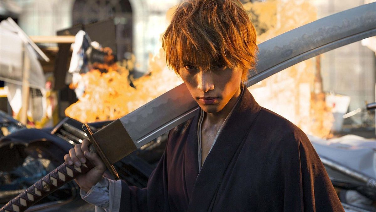 Sota Fukushi as Ichigo Kurosaki holding a large sword in front of a fire in Bleach.