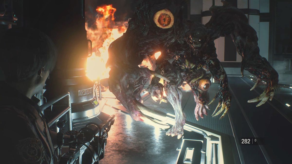 Leon Kenney aims his flamethrower at William Birkin in his final form in a screenshot from Resident Evil 2 (remake)