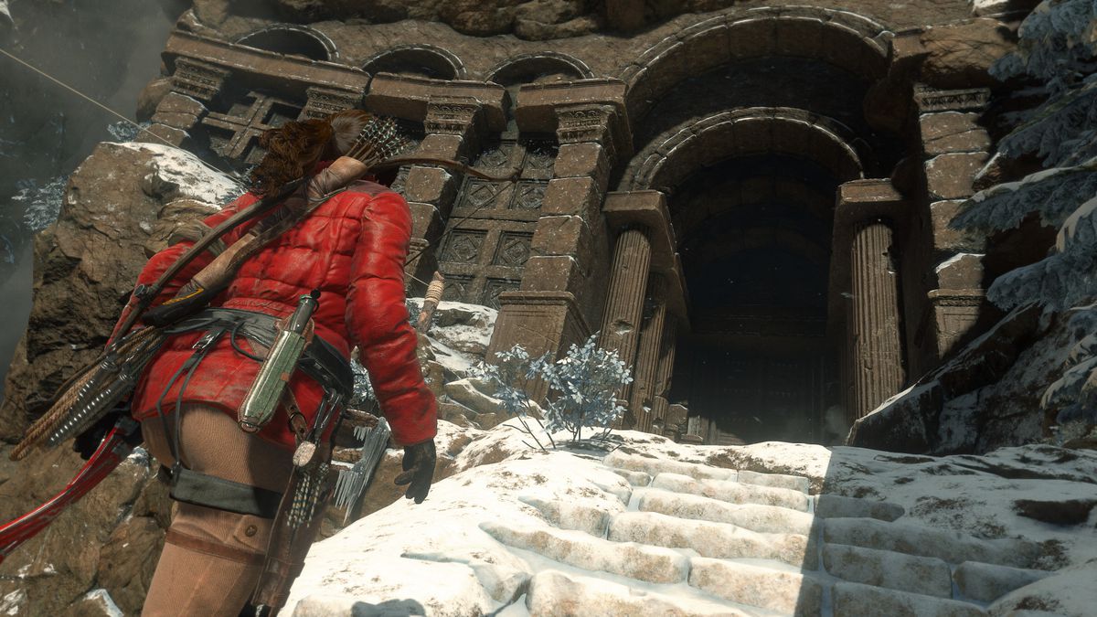 Lara Croft in a red winter jacket walking up the snowy steps of a temple in Rise of the Tomb Raider.