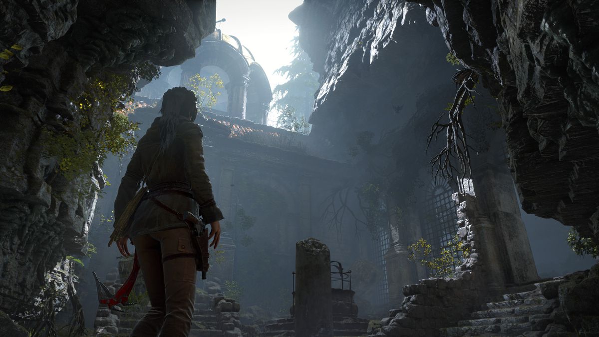 Lara Croft standing in a cavernous ruin in Rise of the Tomb Raider.