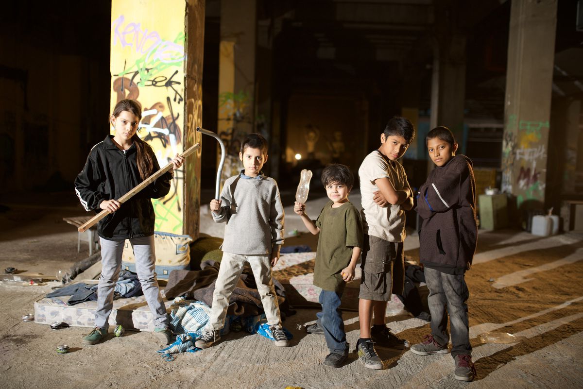 The orphans of Tigers Are Not Afraid, posing with scrap weapons under an overpass.