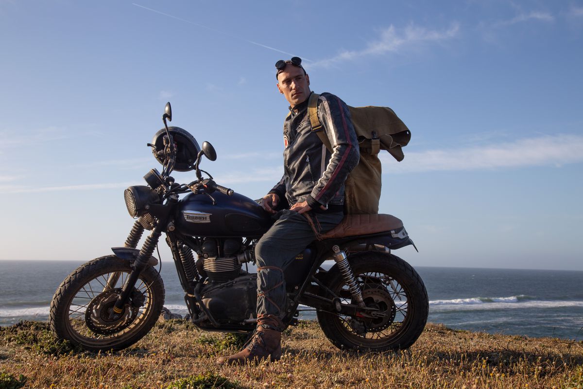 Marko Zaror looks cool as hell on a motorcycle, wearing a leather jacket and with goggles on top of his head, in Fist of the Condor, with the ocean behind him.