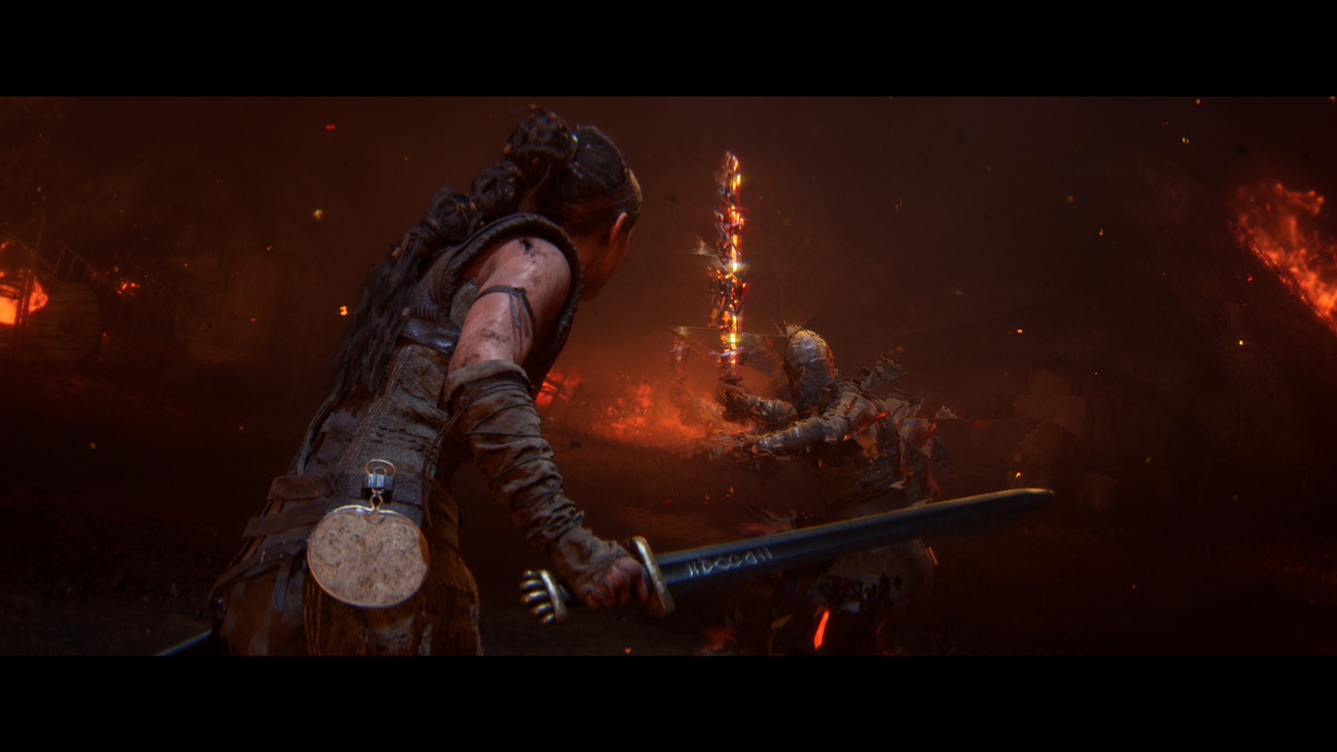 Senua, seen from the waist up, holds a sword with her back to the player. She faces an indistinct enemy holding a fiery sword whose appearance is fractured