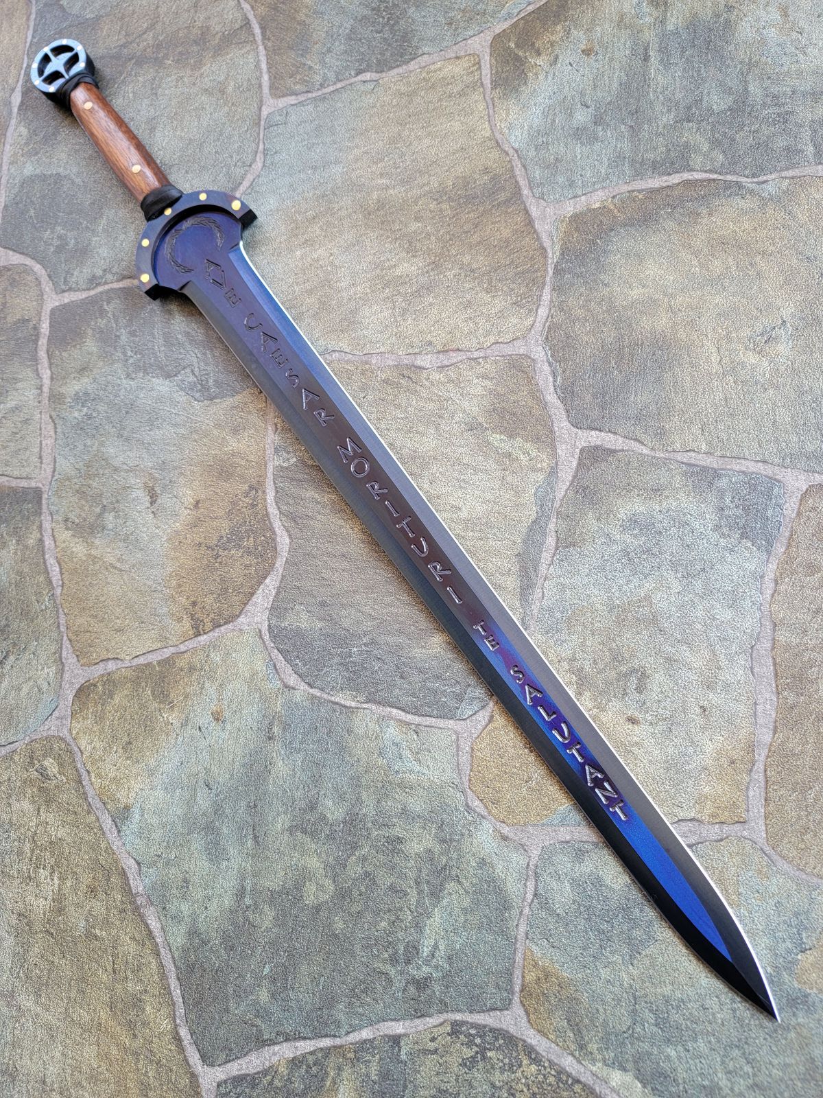 A blued Roman gladius with a tapered point. It reads Ave Caesar Morituri Te Salutant, which the company says translates to “hail Caesar, we who are about to die salute you”