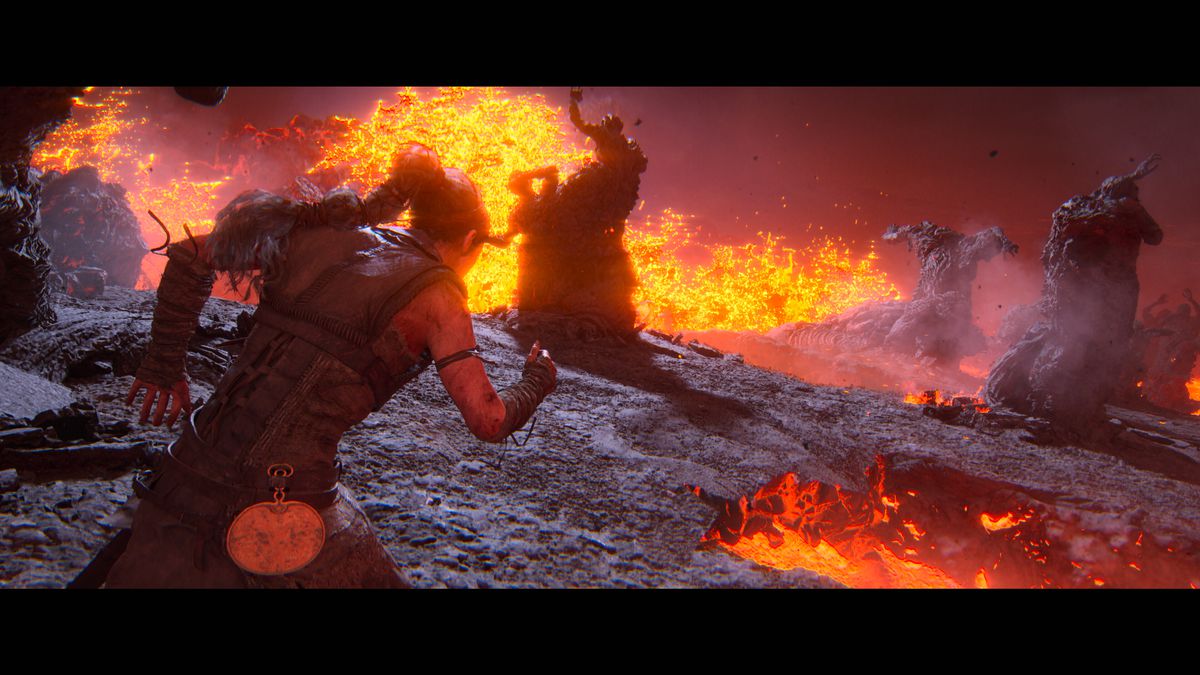 Hellblade 2’s Senua struggles forward through a volcanic landscape with eruptions of lava and rock-like statues of tortured-looking human figures