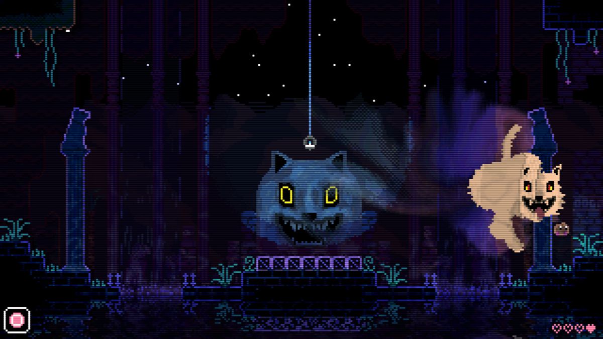 A screenshot of Animal Well depicting a large statue of a dog’s grinning head, with a nearby massive ghost of a similar-looking dog hovering and grinning creepily at a tiny egg (the game’s protagonist) bouncing away from it towards the right side of the screen