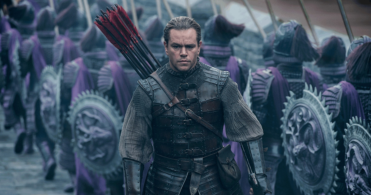 Matt Damon, with arrows on his back, walks by a group of soldier in purple armor in The Great Wall