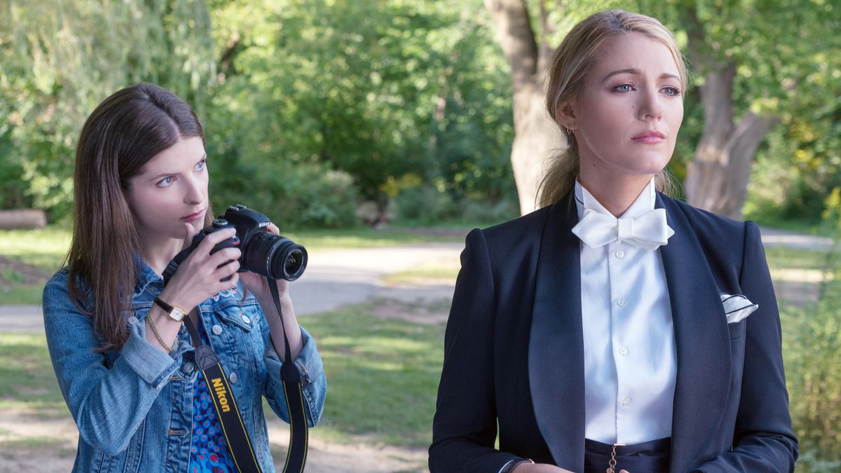 Anna Kendrick takes a photo of Blake Lively, wearing a suit with a white bowtie, in A Simple Favor