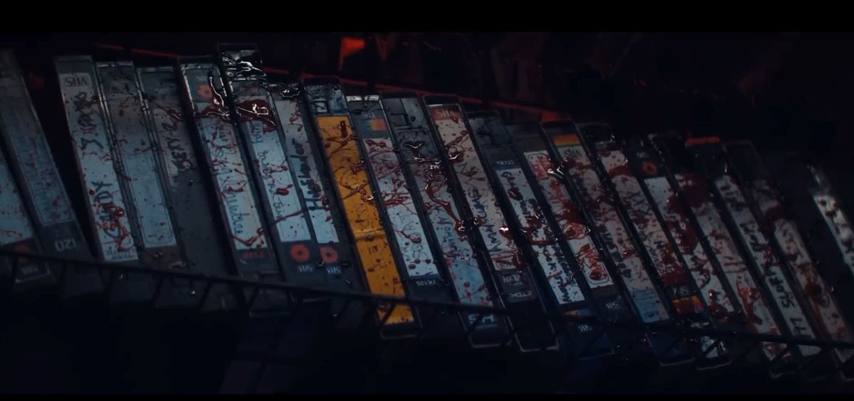 A row of VHS tapes in Leon’s video store, splattered with blood, from the trailer for Ti West’s Maxxxine