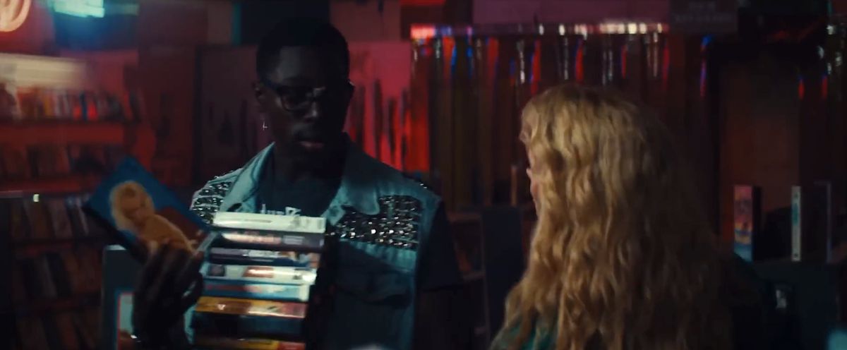 Leon (Moses Sumney) and Maxine (Mia Goth) stand together in his video store, in a blurry/grainy shot that deliberately looks like it was shot on 1980s-era videotape, in Ti West’s Maxine