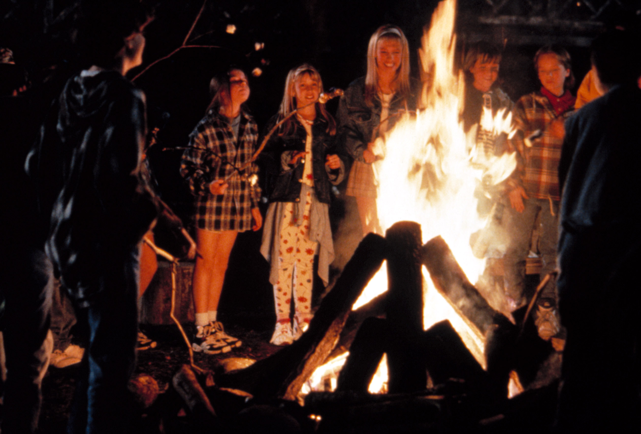 A group of teenagers and kids gather by a campfire in Camp Nowhere