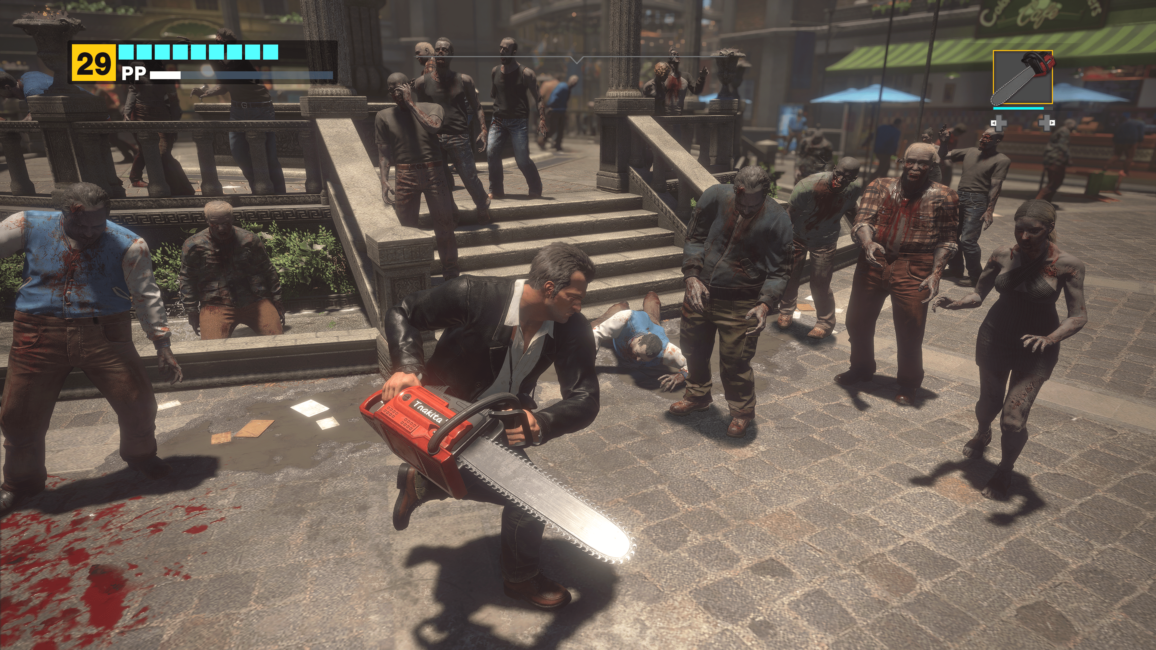 Frank West uses a chainsaw against a group of zombies in a screenshot from Dead Rising Deluxe Remaster