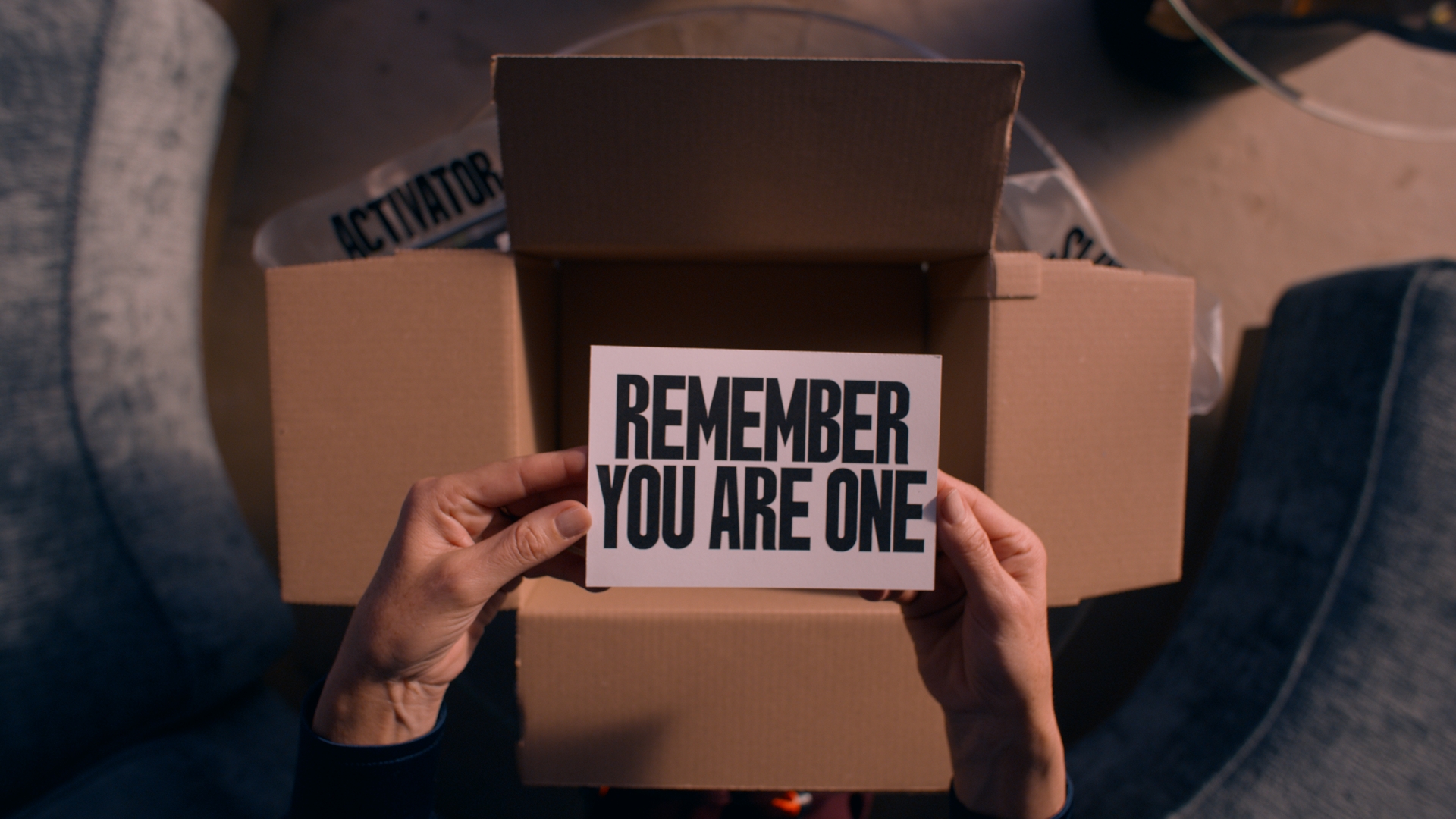 A shot from The Substance of Elisabeth holding the card from the package that says “REMEMBER YOU ARE ONE” 