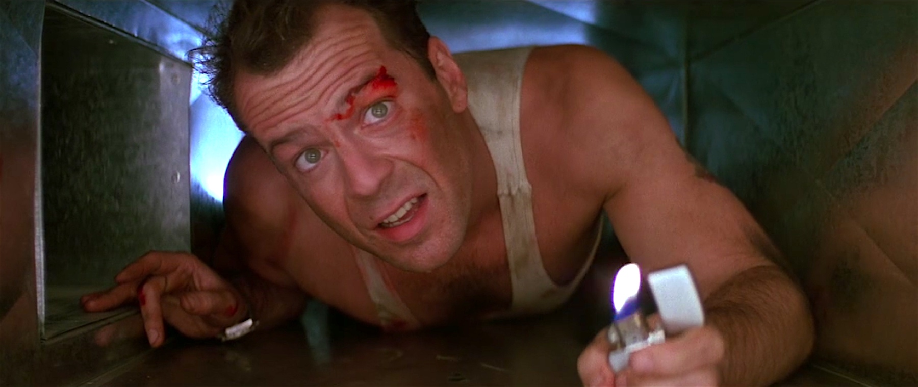 John McClane crawls through an air duct in a still from Die Hard