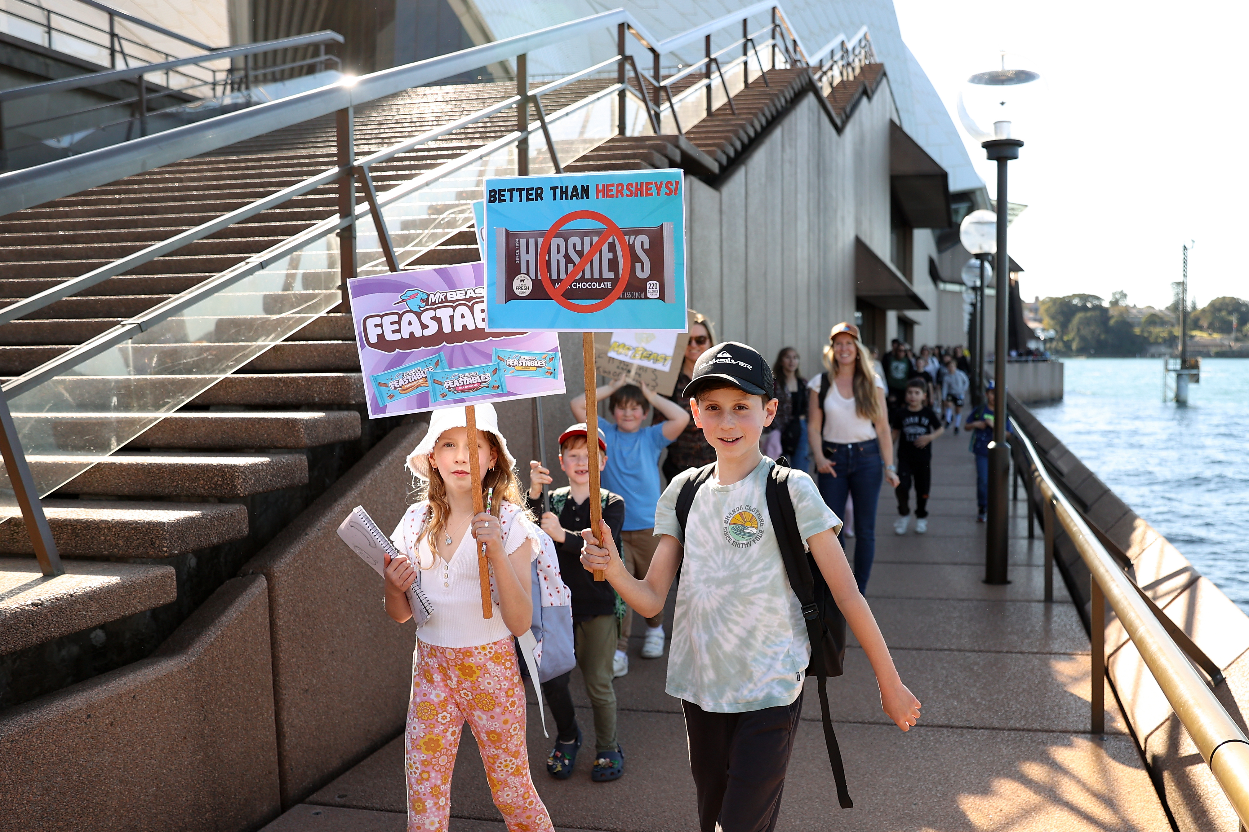 Kids hold anti-Hershey’s signs at a MrBeast Feastables rally in Australia