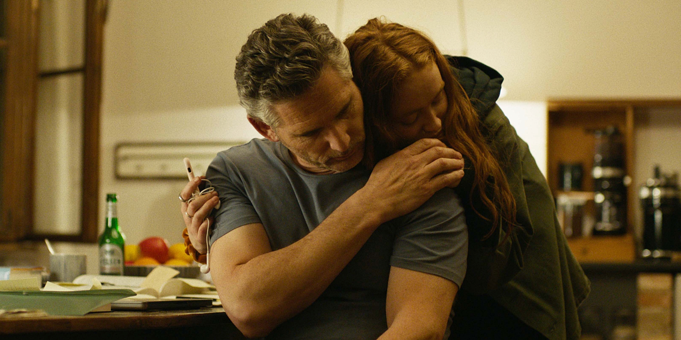 A man (Eric Bana) being consoled by a young girl (Sadie Sink) in A Sacrifice.