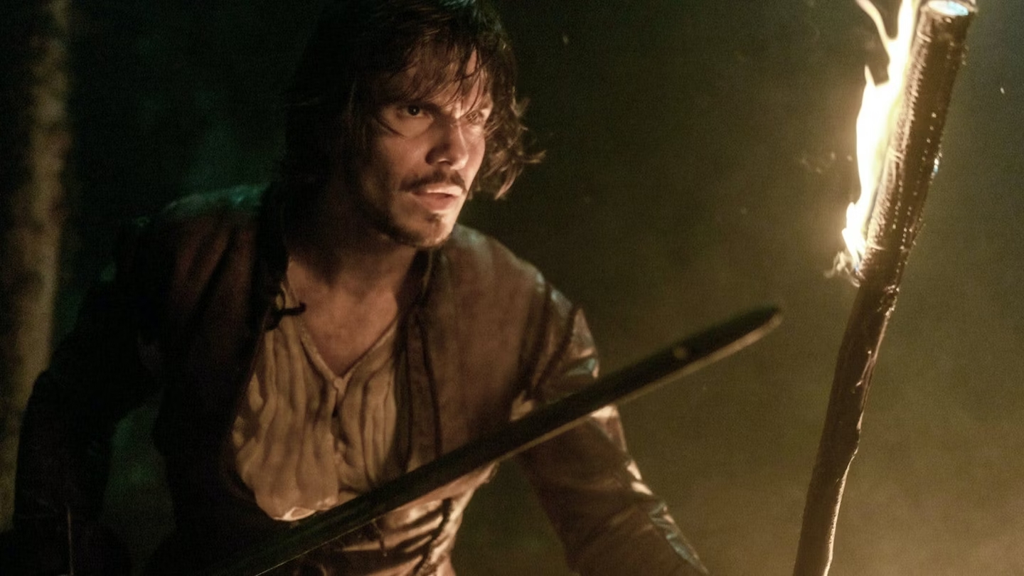 A man holding a sword and flaming torch in The Three Musketeers – Part I: D'Artagnan.