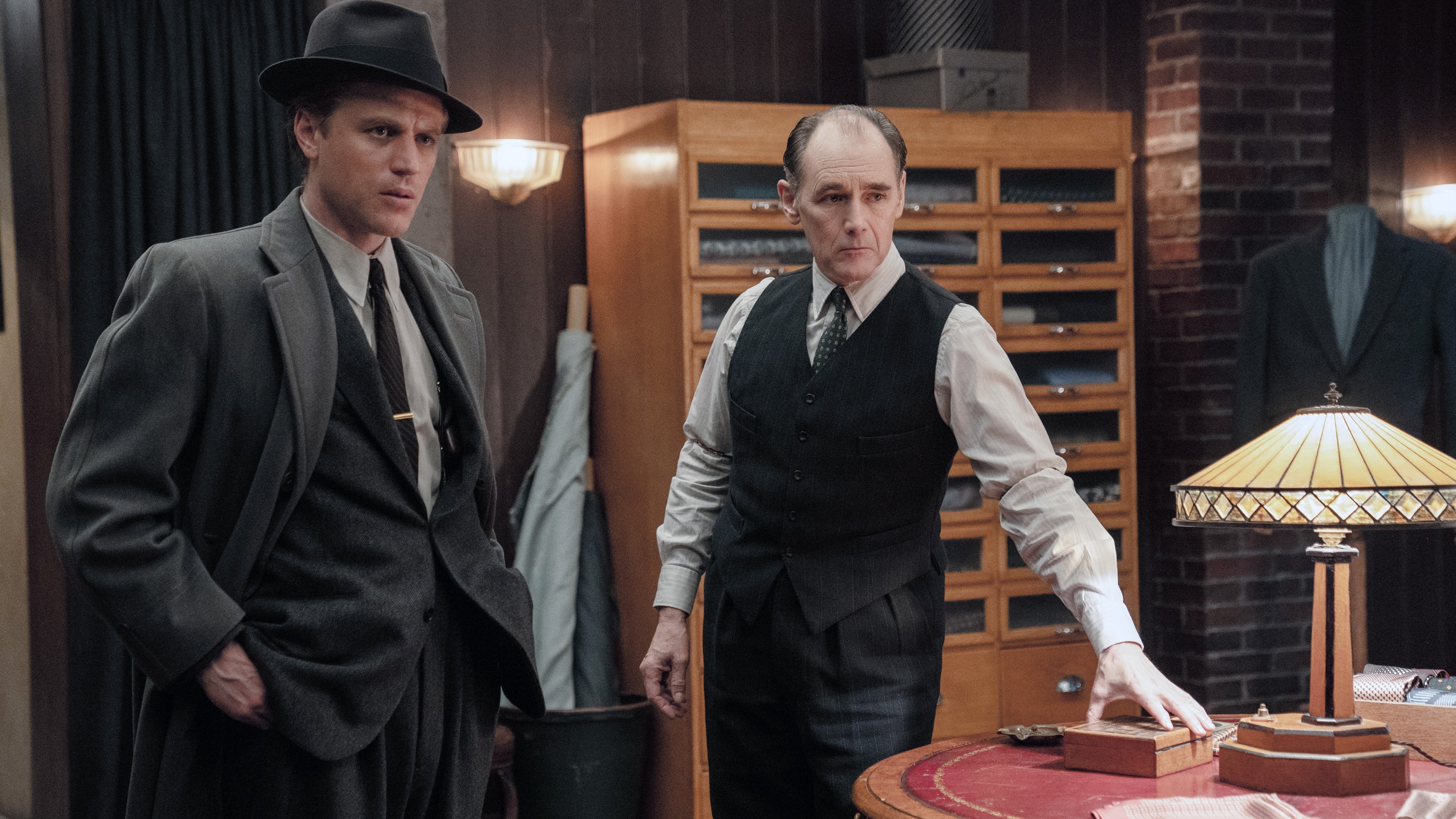 Mark Rylance and Johnny Flynn, wearing fancy clothes, stand in a tailor shop in The Outfit