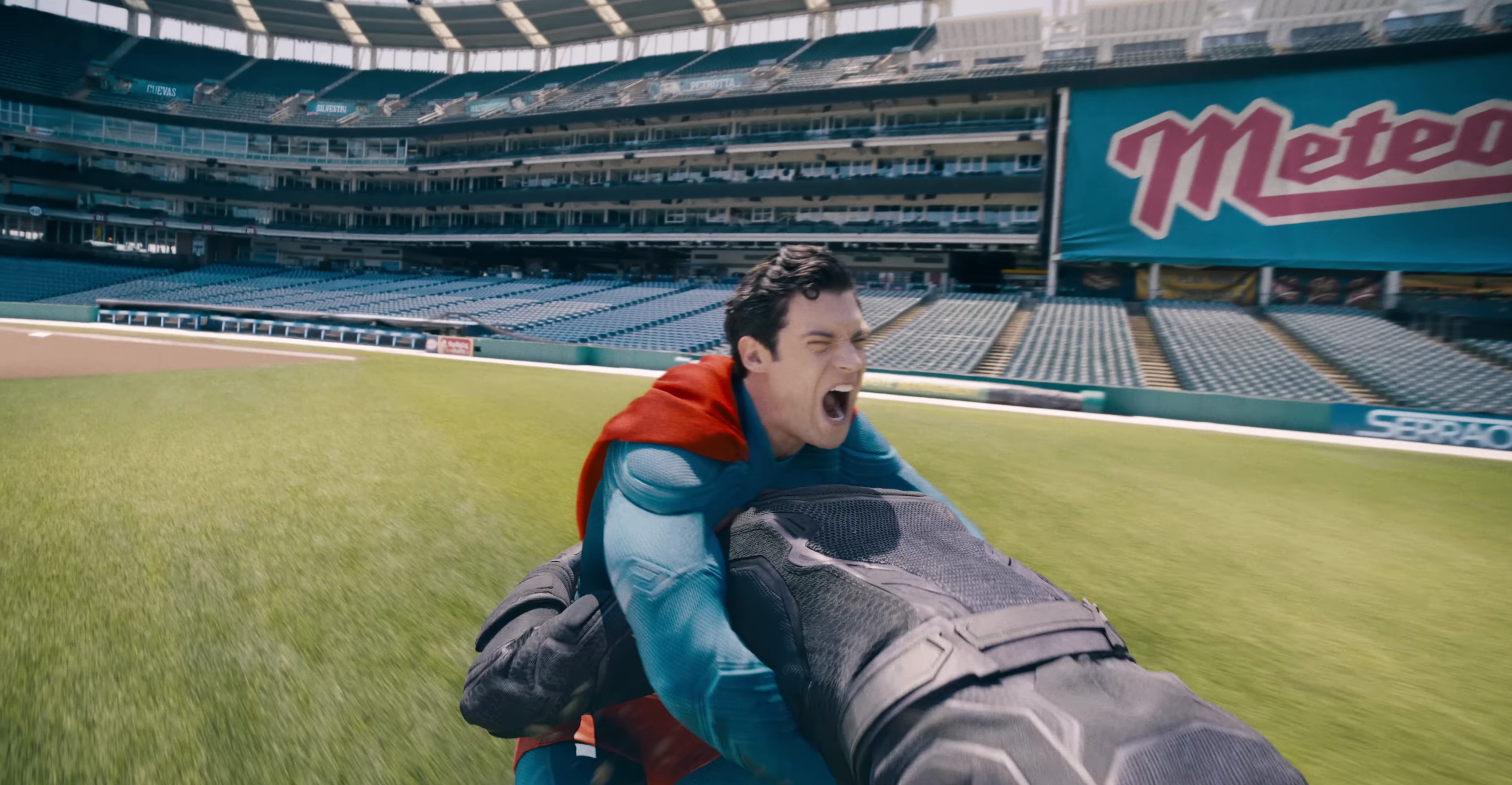 Superman fights a guy in black leather in a baseball field in Superman 2025