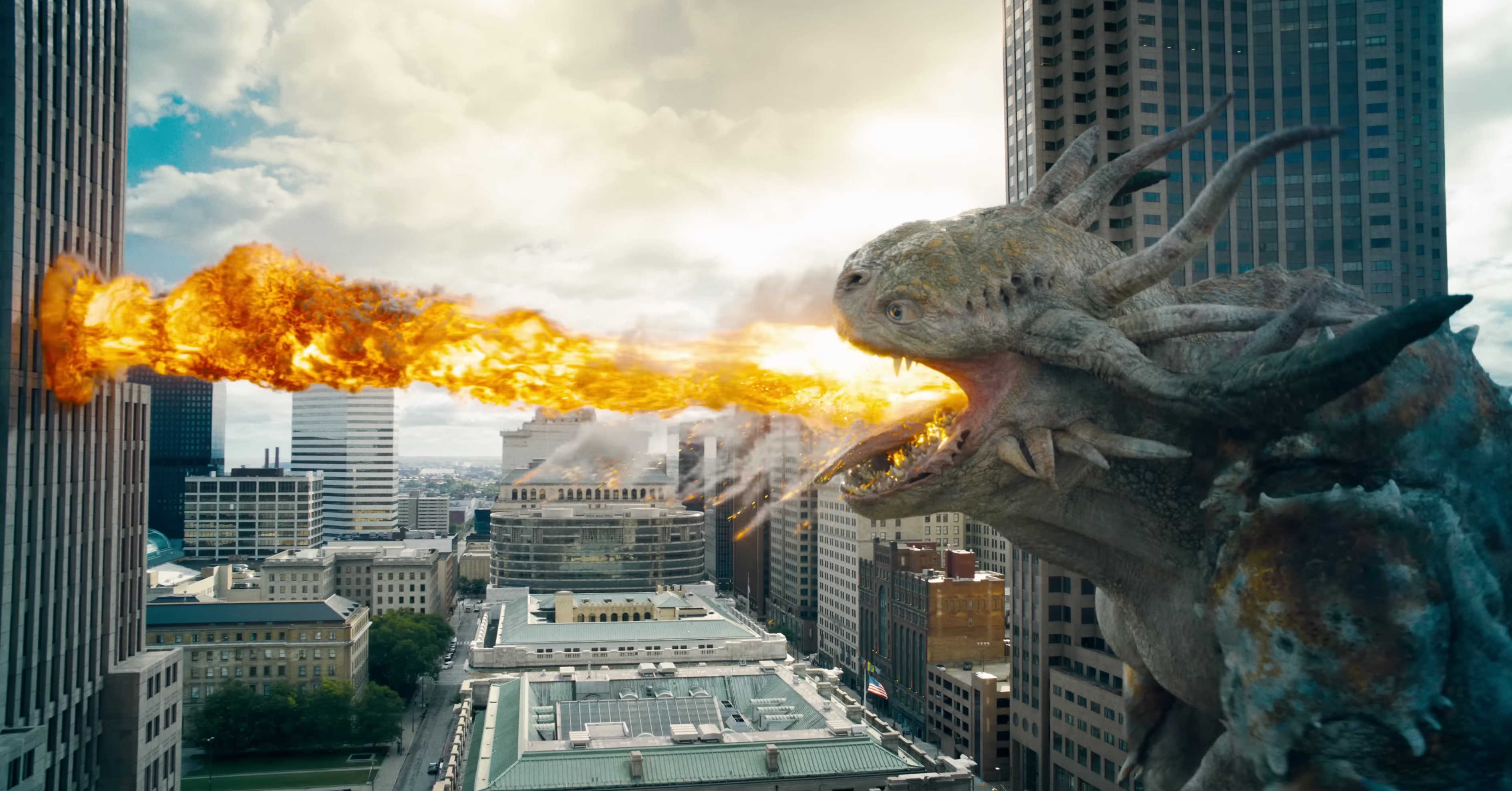 A Kaiju breathes fire at a building in Superman 2025