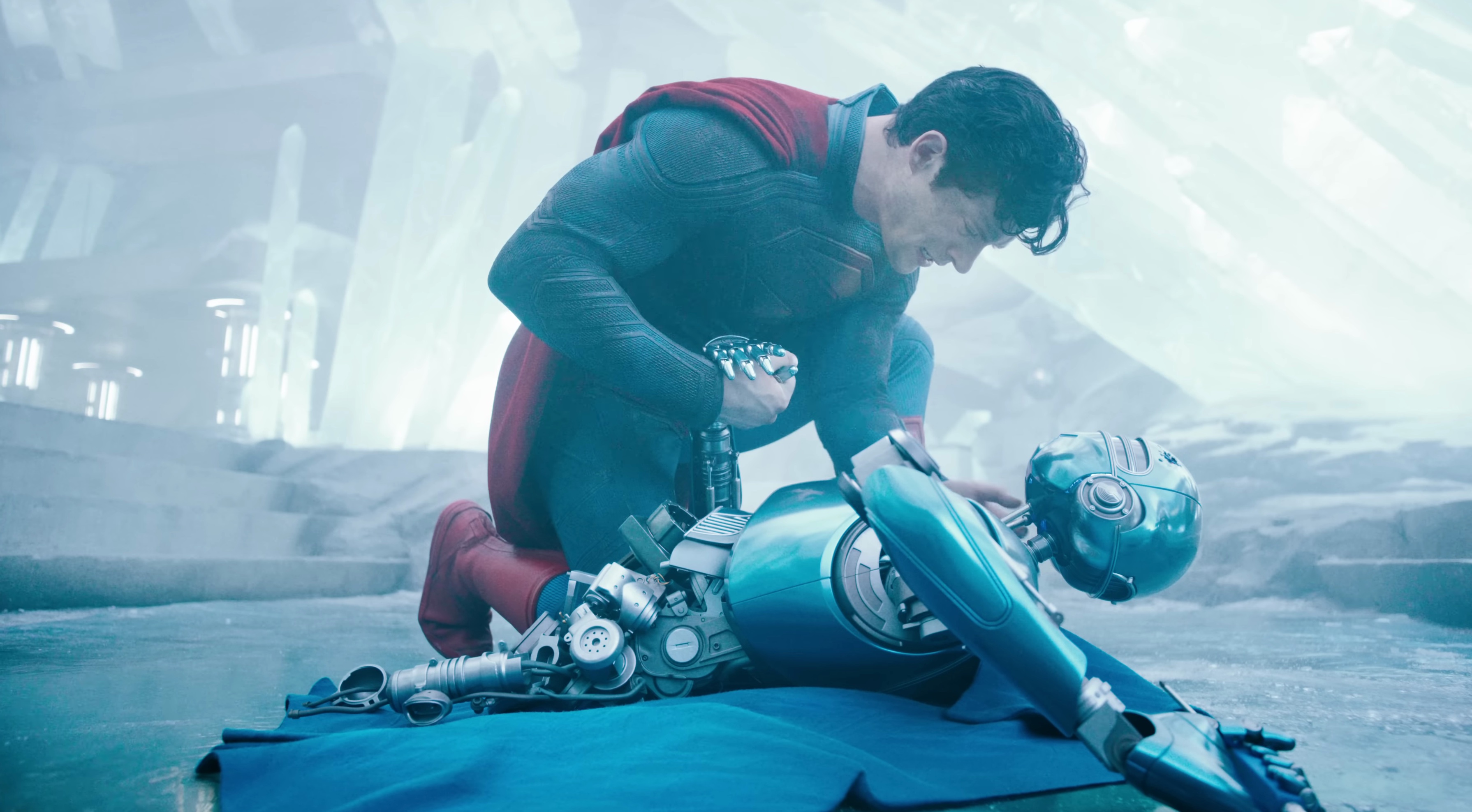 Superman holds a dying robot in the 2025 movie