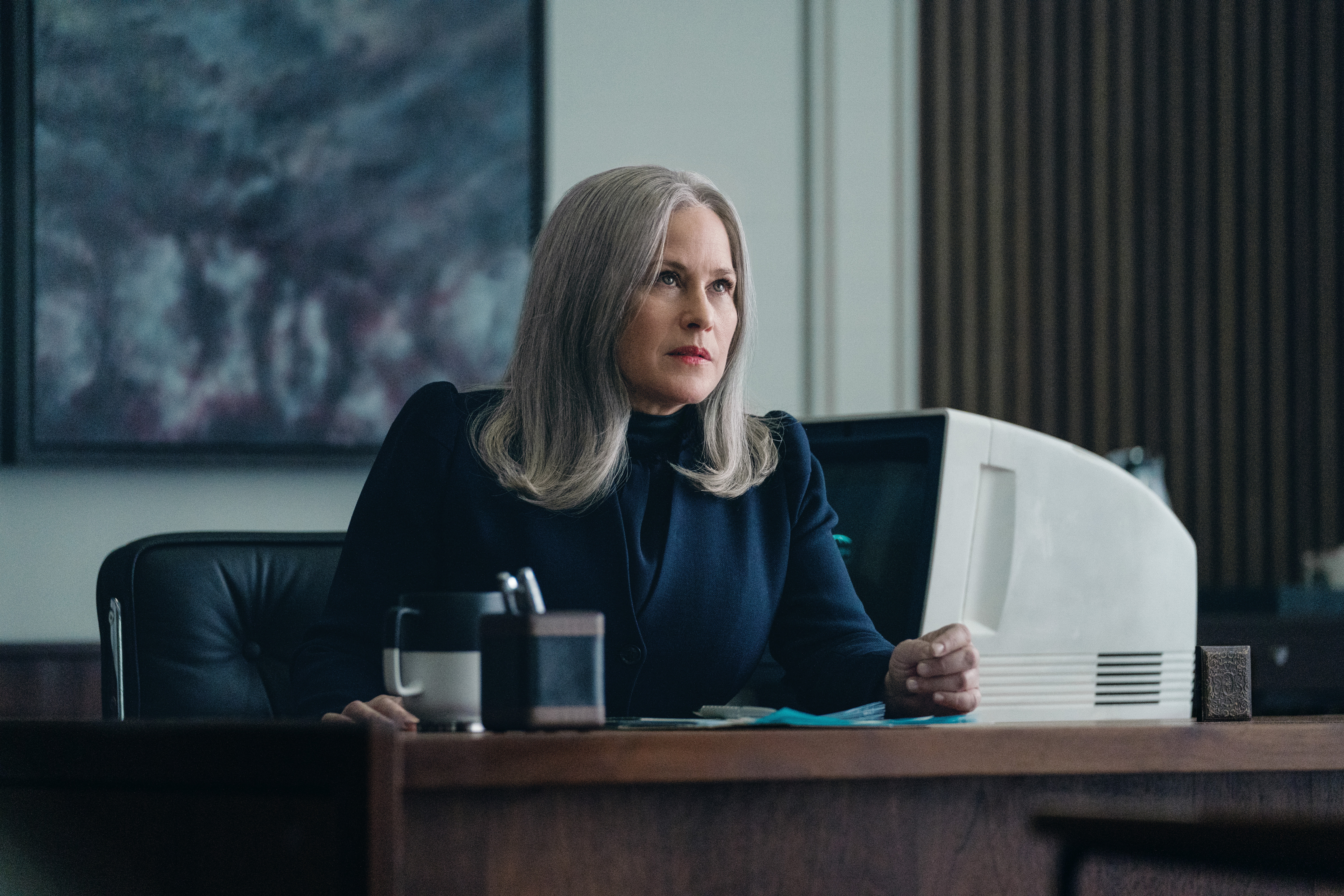 Patricia Arquette sitting at a desk in Severance