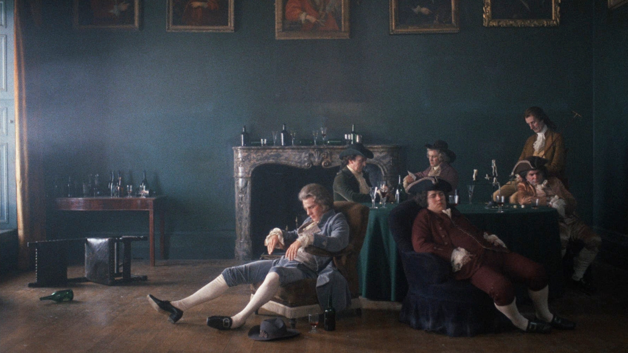 A man in a powdered wig seated in a parlor surrounded by empty bottles of alcohol and several other drunken men in Barry Lyndon.