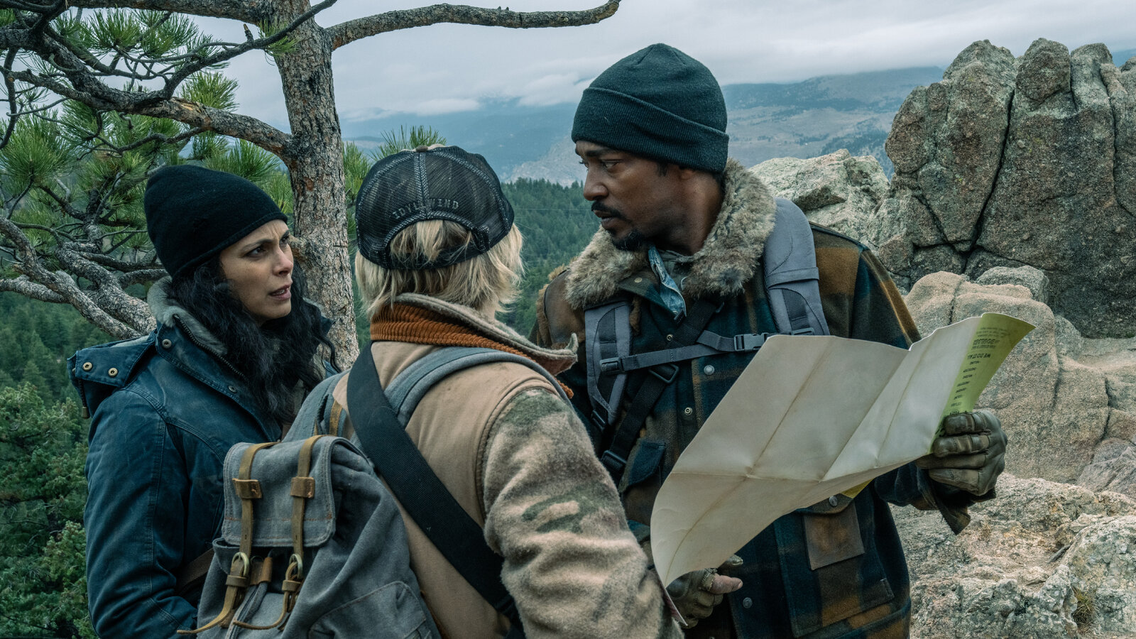 Anthony Mackie and Morena Baccarin looking at a map in the wilderness in Elevation.