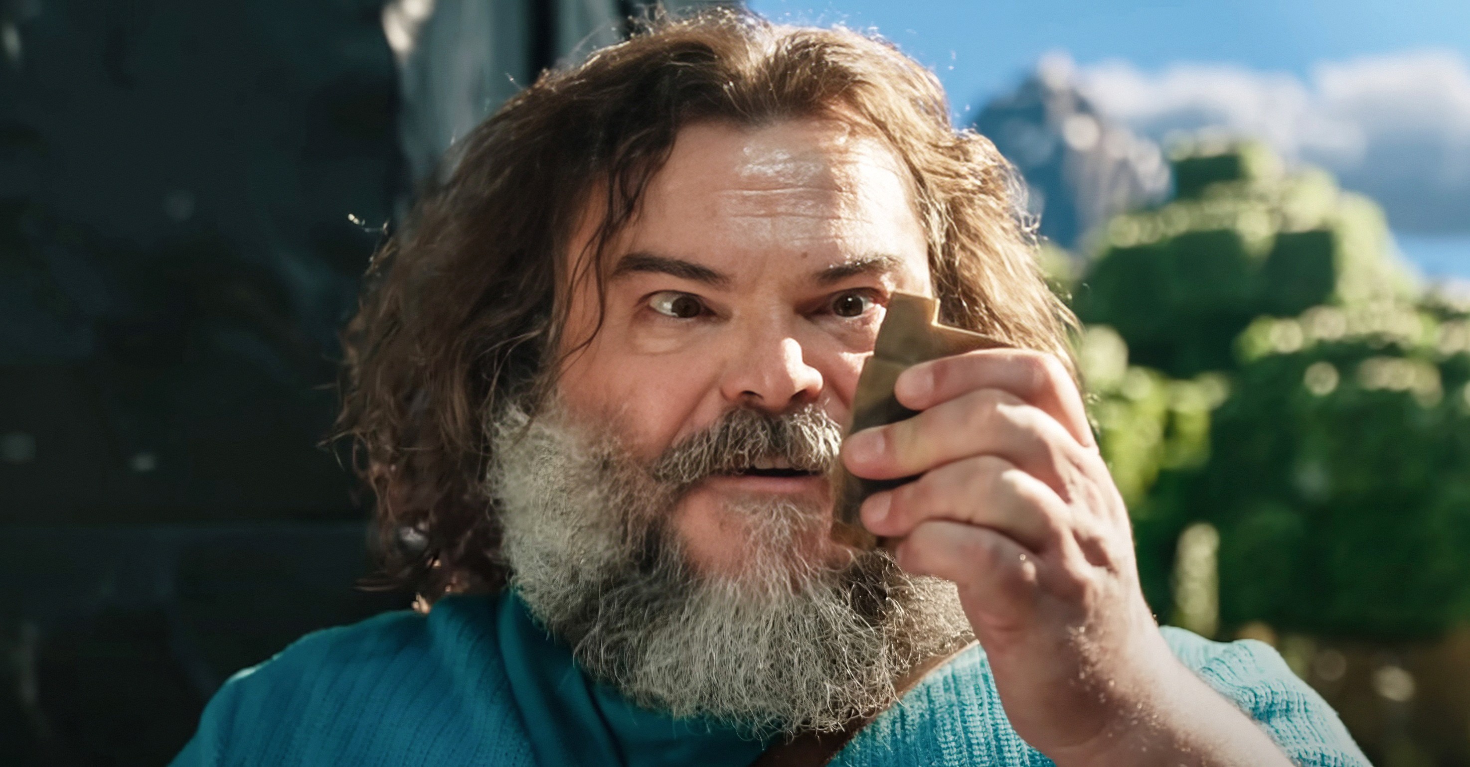 Jack Black as Steve in A Minecraft Movie, looking intently at some ore.