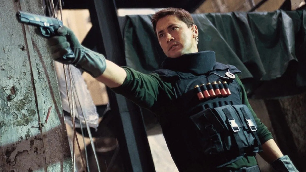 In Beast Cops, Michael Wong wears a bulletproof vest and holds a pistol out