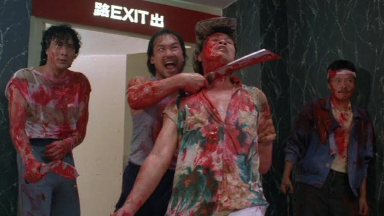 Four extremely blood-covered men in Hong Kong Godfather. One holds a machete to another’s throat, while two others wait behind him.