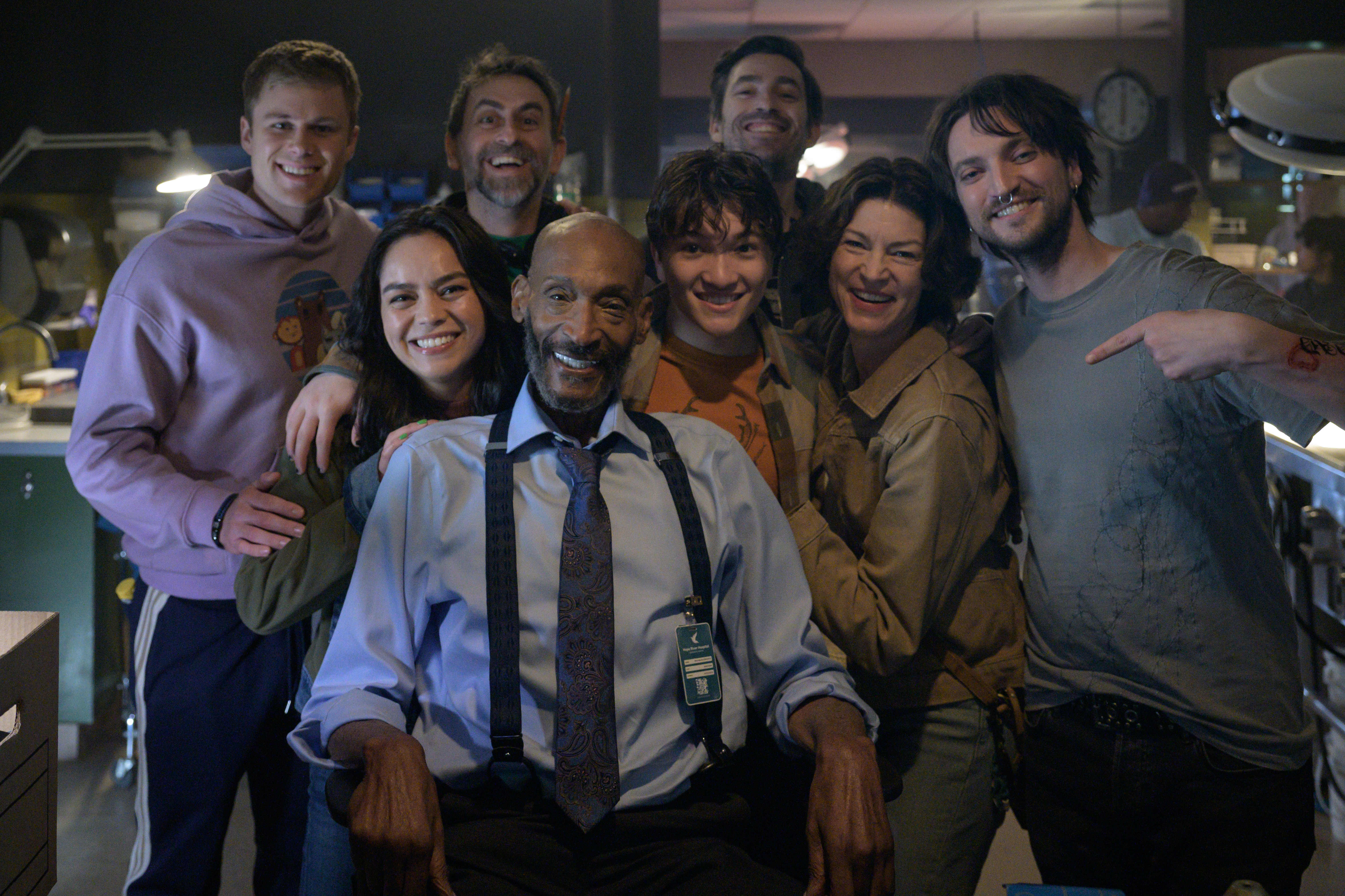 Tony Todd sitting on the set of Final Destination: Bloodlines, surrounded by the lead cast and directors Zach Lipovsky and Adam B. Stein, all smiling at the camera
