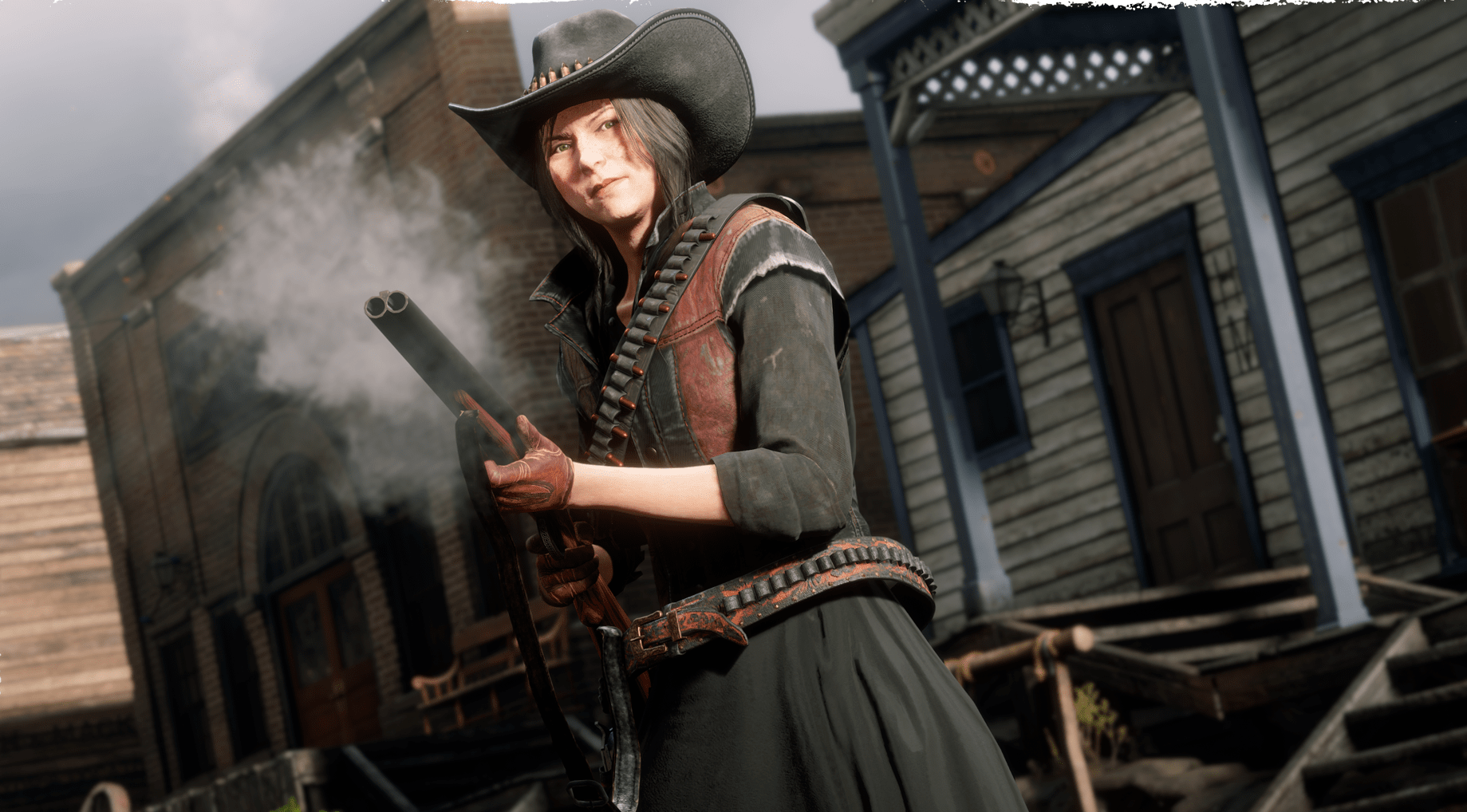Red Dead Online - a young woman clutches a smoking shotgun. She’s dressed in red and black, with a cowboy hat and skirts on, and has black hair. She looks determined.