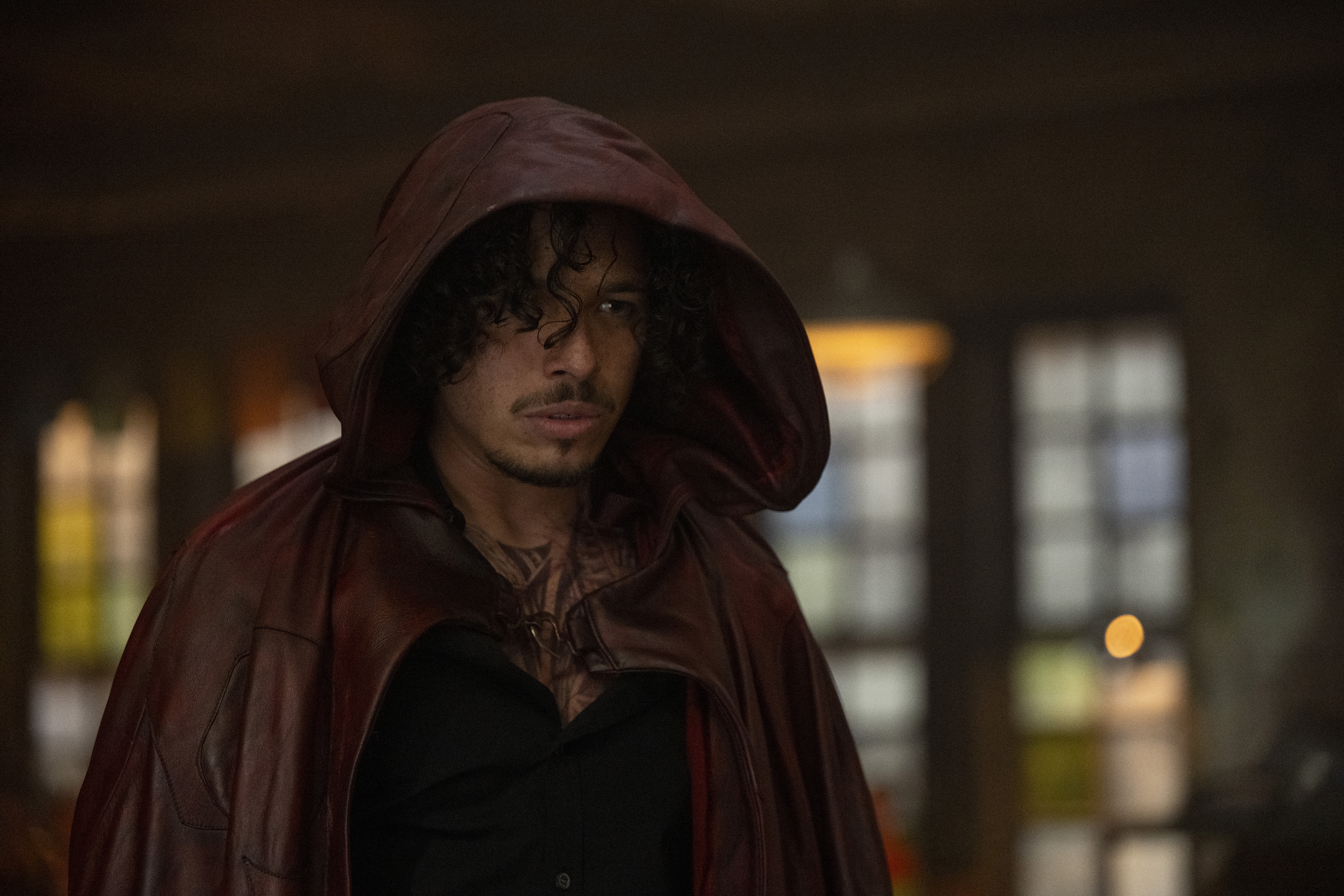 Anthony Ramos as Peter Robinson, standing in a red hood from Marvel’s Ironheart series